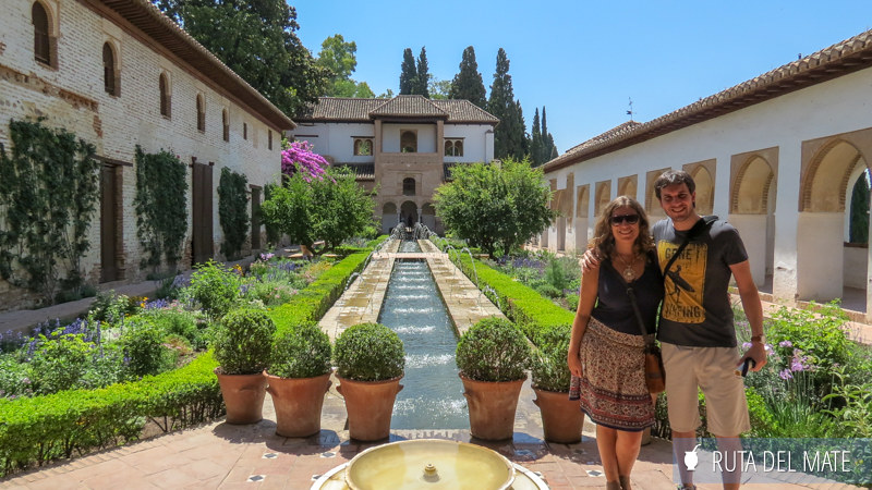 Flor y Juan en los jardines de La Alhambra, adornado con macetas y un pequeño estanque de agua