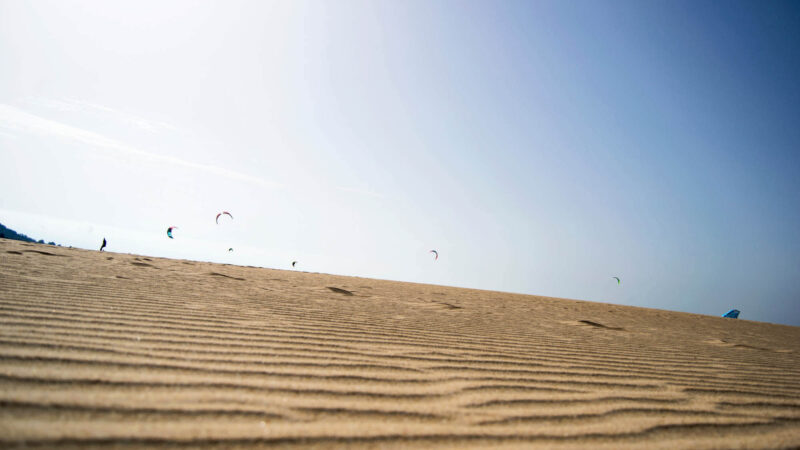 Personas haciendo kitesurf en la playa de Valdevaqueros