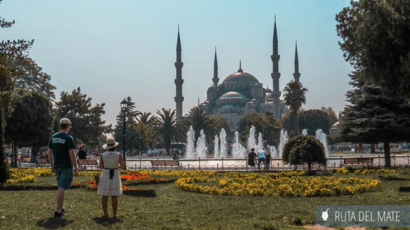 Una pareja parada de espaldas frente a la Mezquita Azul de Estambul