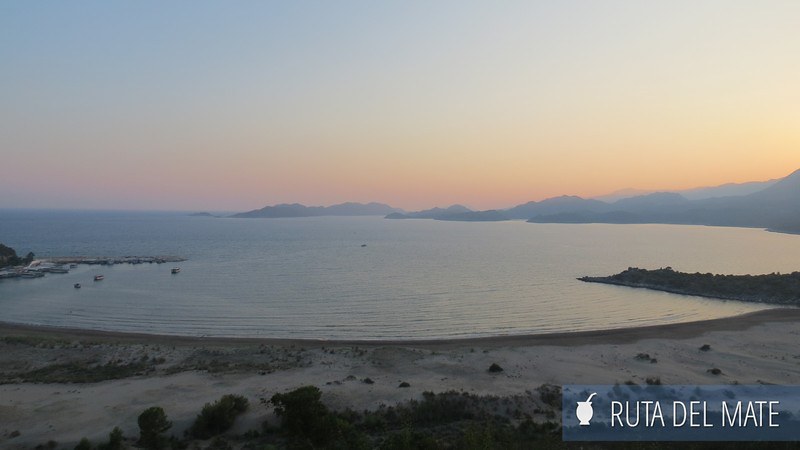 Bahía y playa desde un mirador al atardecer. Colores anaranjados típicos de esa hora del día. Está cerca de la playa de Patara. Se pueden ver pequeños barcos en la distancia y una isla