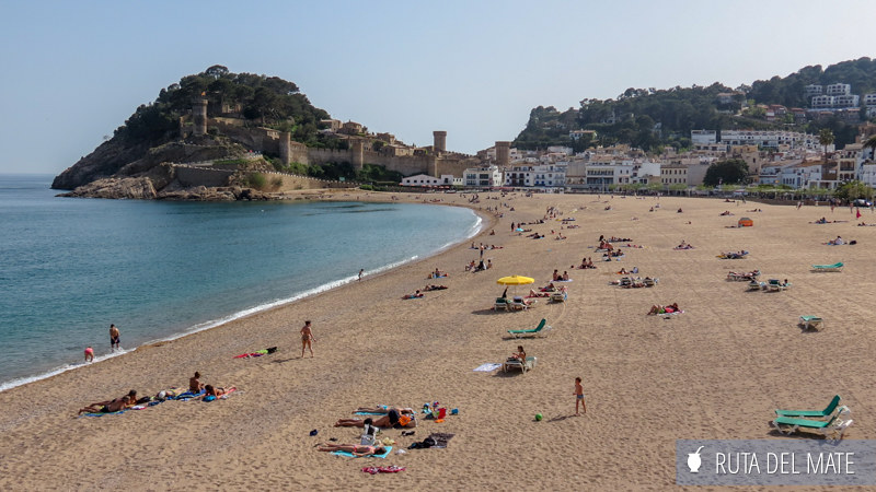 The wide beach of Tossa de Mar with the medieval castle ruins in the background
